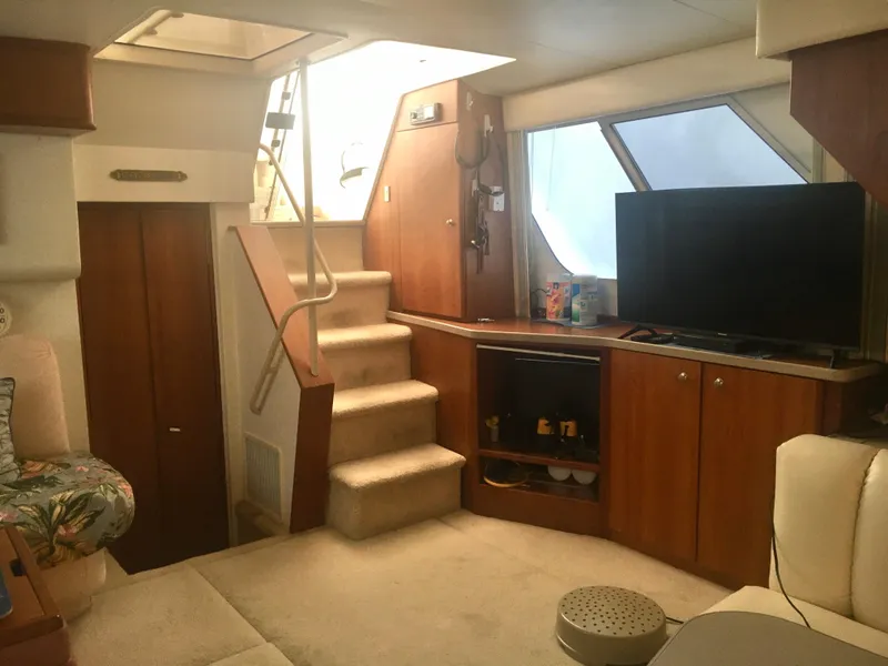 Slide: The Image of Interior of a 1996 Silverton 372 Motor Yacht with stairs, TV, and cozy seating area. - 27