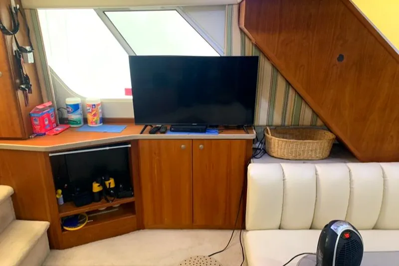 Slide: The Image of Interior of 1996 Silverton 372 Motor Yacht with TV, cabinets, and seating area. - 28