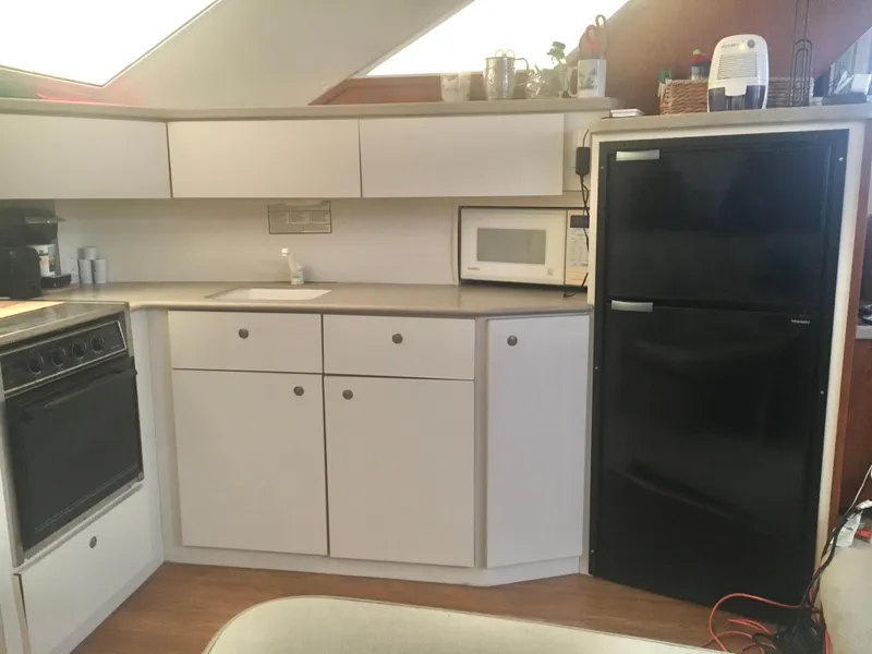 Slide: The Image of 1996 Silverton 372 Motor Yacht kitchen with stove, microwave, and refrigerator. - 36