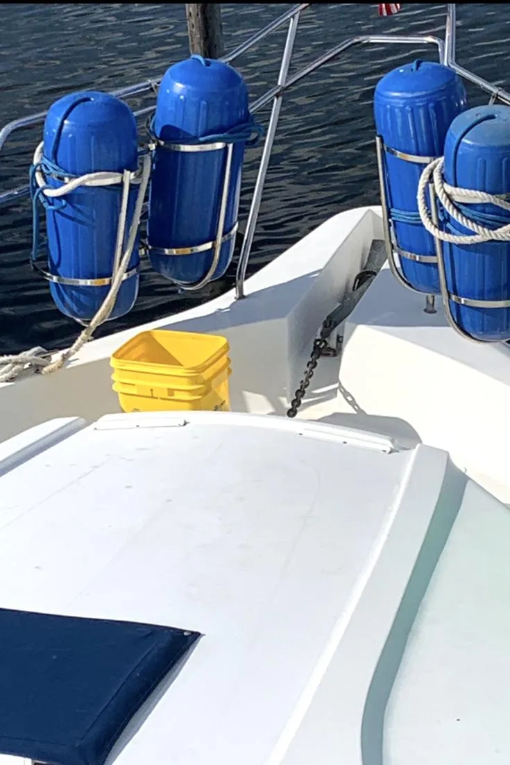 Slide: The Image of 1996 Silverton 372 Motor Yacht deck with blue fenders and a yellow bucket. - 6