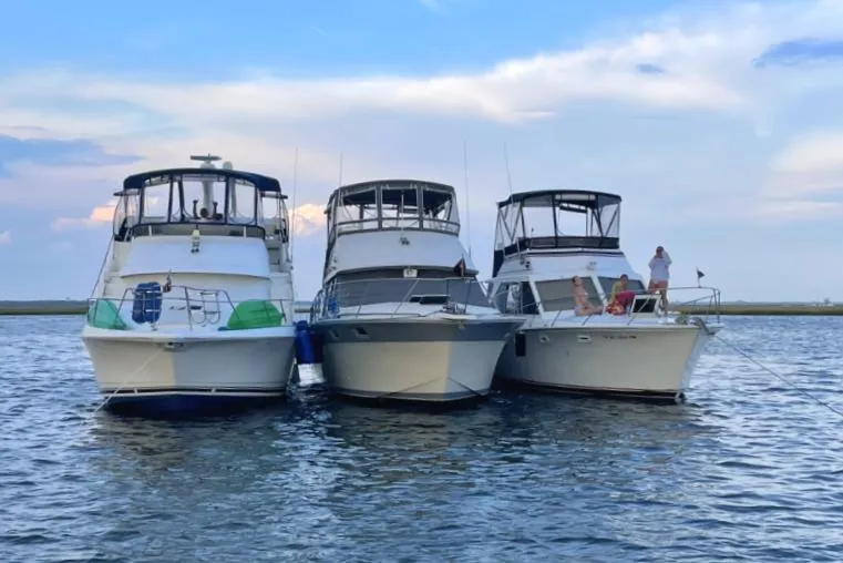 Slide: The Image of Three yachts, including a 1996 Silverton 372 Motor Yacht, anchored together on calm water. - 8