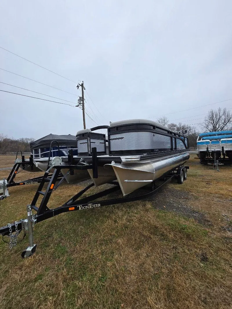 Slide: The Image of 2025 Qwest E-Class 22 XRE Cruise pontoon boat on trailer, parked on grass. - 3