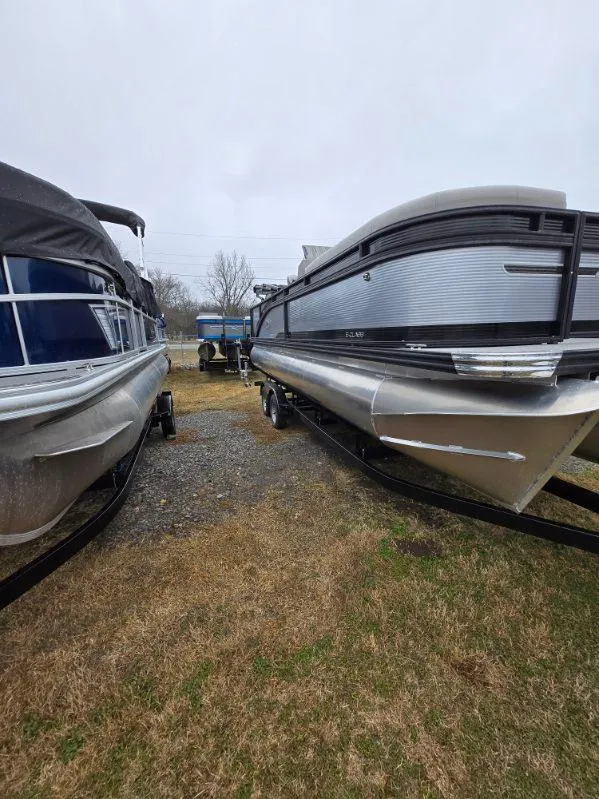 Slide: The Image of 2025 Qwest E-Class 22 XRE Cruise pontoon boats on display outdoors. - 6