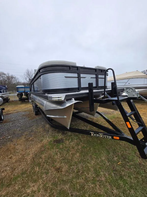 Slide: The Image of 2025 Qwest E-Class 22 XRE Cruise pontoon boat on trailer, parked on grass. - 7