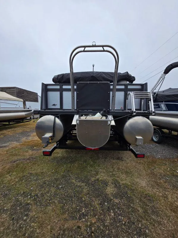 Slide: The Image of 2025 Qwest E-Class 22 XRE Cruise pontoon boat, rear view, parked on grass. - 8