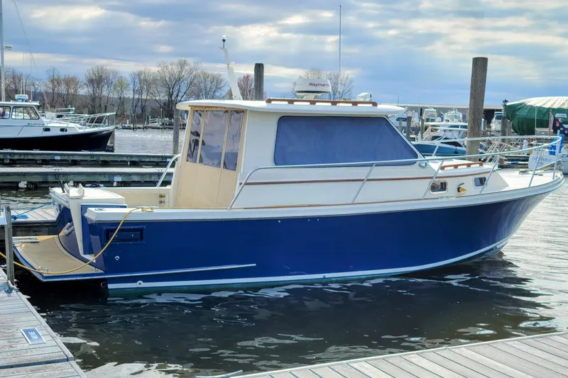 Slide: The Image of 2000 Hunt Yachts 28 Hardtop Express docked in a marina, featuring a sleek blue hull. - 0