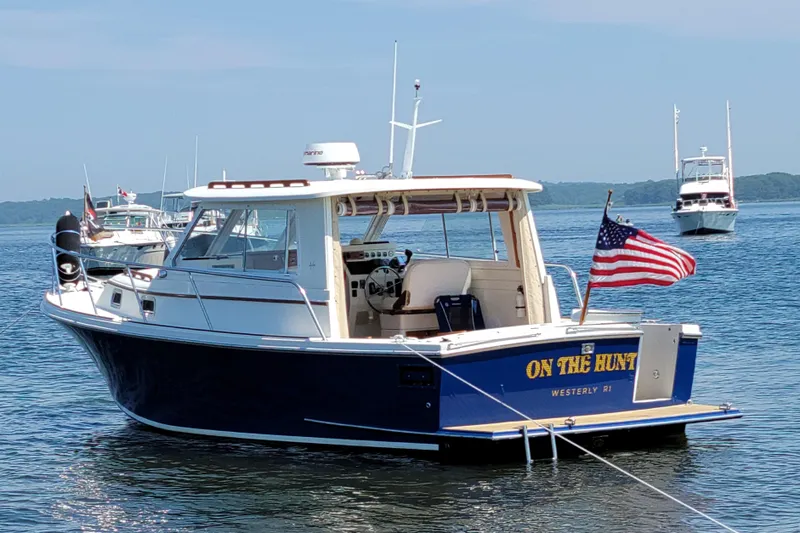 Slide: The Image of Hunt Yachts 28 Hardtop Express 2000 on water, displaying American flag. - 1