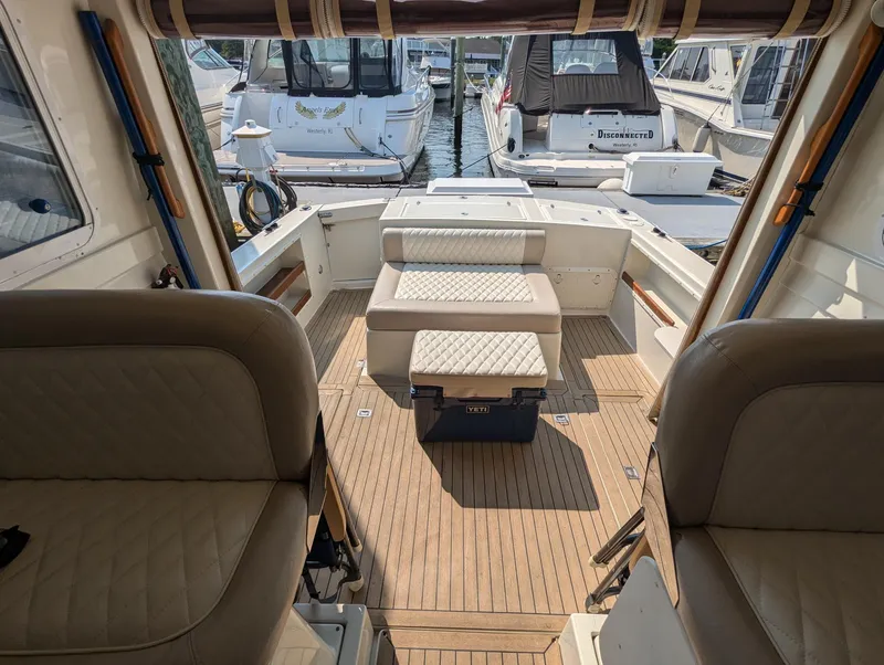 Slide: The Image of 2000 Hunt Yachts 28 Hardtop Express interior with seating and wooden deck. - 12
