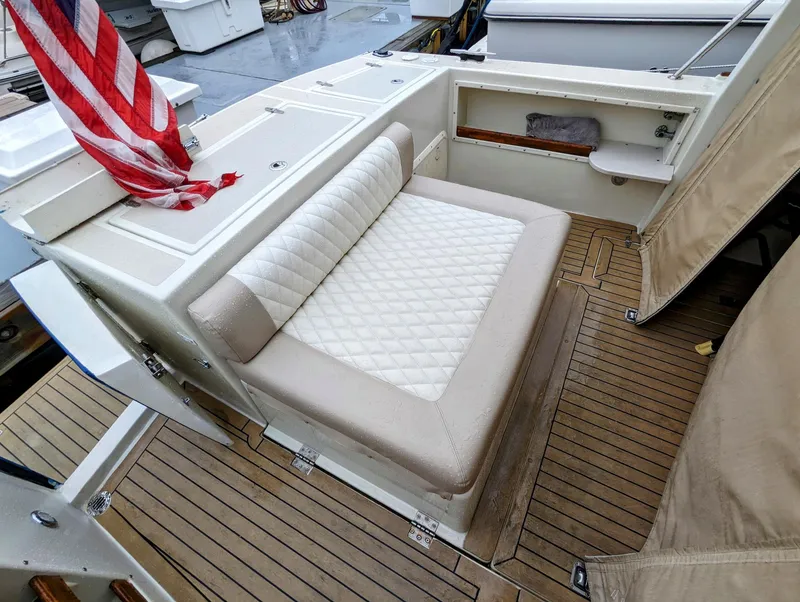 Slide: The Image of Hunt Yachts 28 Hardtop Express 2000, featuring a cushioned seating area and wooden deck. - 14