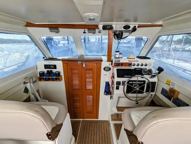 Slide: The Image of Interior of 2000 Hunt Yachts 28 Hardtop Express, featuring helm and seating area. - 18