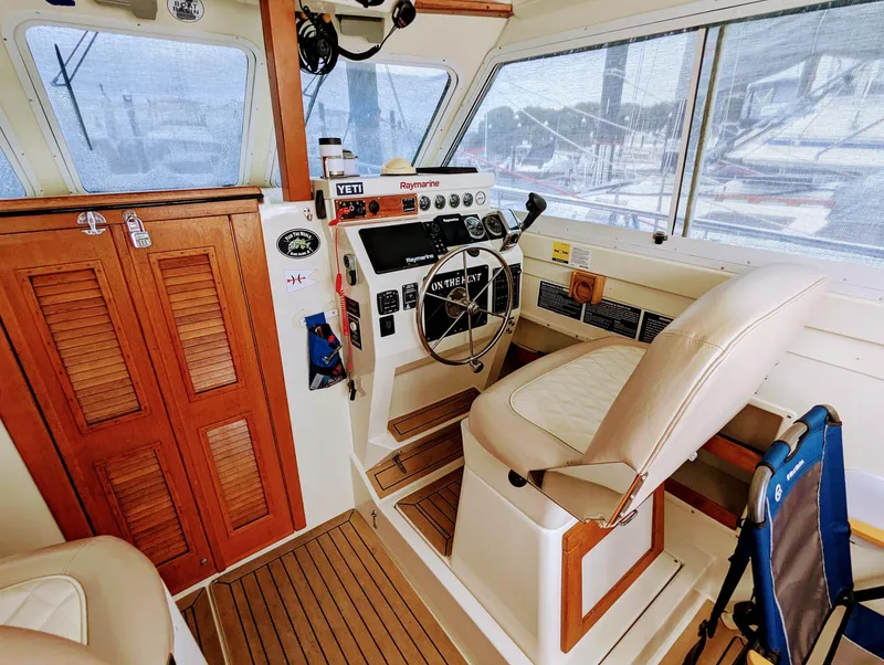 Slide: The Image of Interior of 2000 Hunt Yachts 28 Hardtop Express, featuring helm and wooden accents. - 19