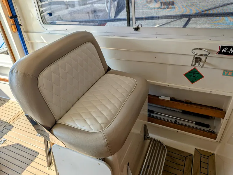 Slide: The Image of Captain's chair on 2000 Hunt Yachts 28 Hardtop Express, featuring quilted upholstery and teak flooring. - 24