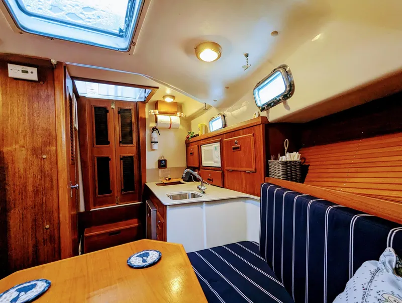 Slide: The Image of Interior of 2000 Hunt Yachts 28 Hardtop Express, featuring cozy seating and compact kitchen. - 28