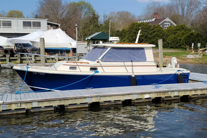 Slide: The Image of 2000 Hunt Yachts 28 Hardtop Express docked at a marina, featuring a classic design. - 3