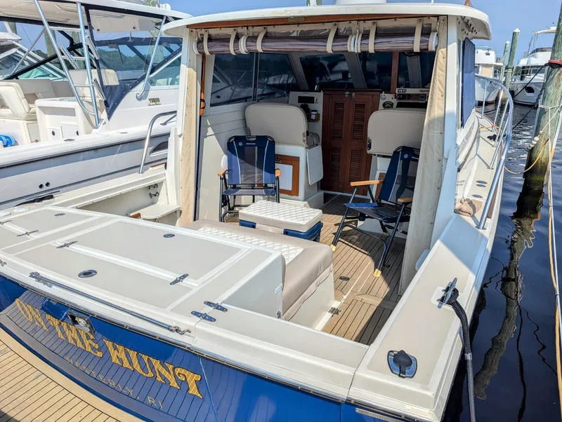 Slide: The Image of 2000 Hunt Yachts 28 Hardtop Express docked, featuring spacious deck and seating area. - 5