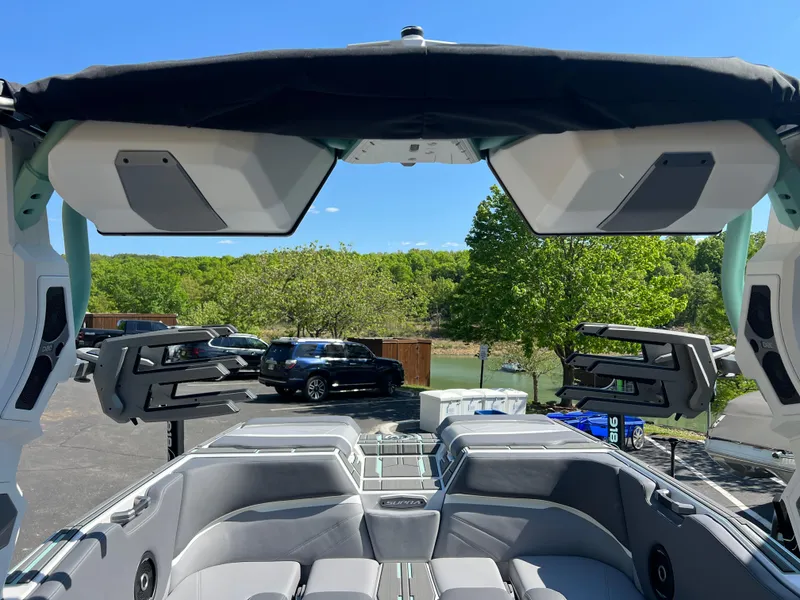 Slide: The Image of 2024 Supra SL boat interior with speakers and seating, parked near a lake. - 16