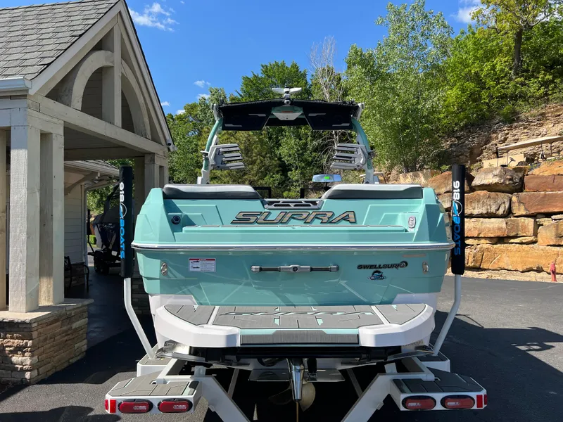 Slide: The Image of 2024 Supra SL boat in a driveway, showcasing its sleek design and modern features. - 2