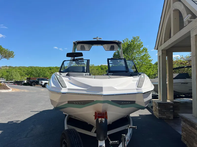 Slide: The Image of 2024 Supra SL boat on trailer, parked outdoors under clear blue sky. - 3