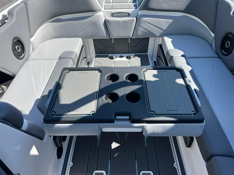 Slide: The Image of 2024 Supra SL boat interior with seating and table featuring cup holders. - 30