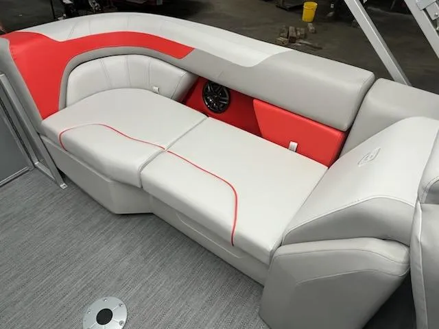Slide: The Image of 2025 Sweetwater 2286SB boat interior with gray and red seating, modern design. - 10