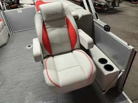 Slide: The Image of 2025 Sweetwater 2286SB boat seat with red accents and cup holders. - 11