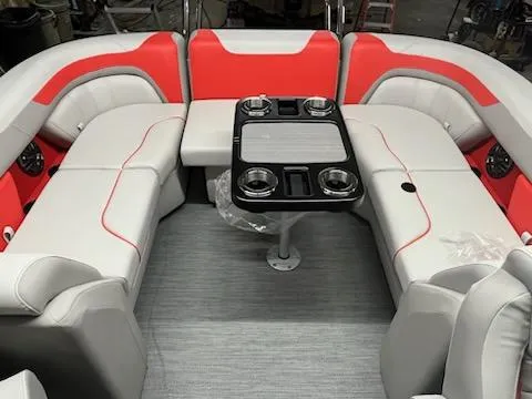 Slide: The Image of 2025 Sweetwater 2286SB boat interior with red and white seating and a central table. - 8
