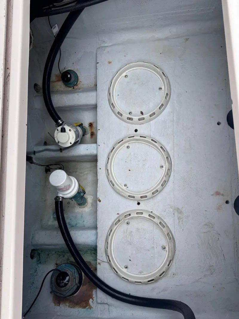 Slide: The Image of 2008 Grady-White 336 Canyon boat compartment with hoses and circular access panels. - 38