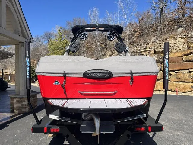 Slide: The Image of 2024 Moomba Mojo boat, red exterior, parked on trailer, rear view. - 10