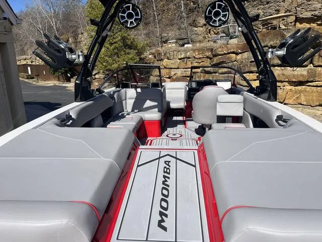Slide: The Image of 2024 Moomba Mojo boat interior with gray seating, red accents, and wakeboard tower speakers. - 11