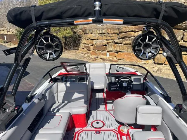 Slide: The Image of 2024 Moomba Mojo boat interior with speakers, red and gray seating, and sleek dashboard design. - 15