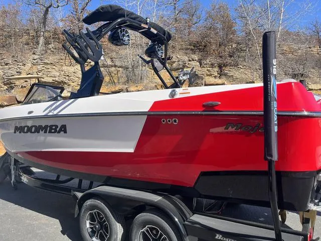 Slide: The Image of 2024 Moomba Mojo boat in red and white on a trailer, parked outdoors. - 17