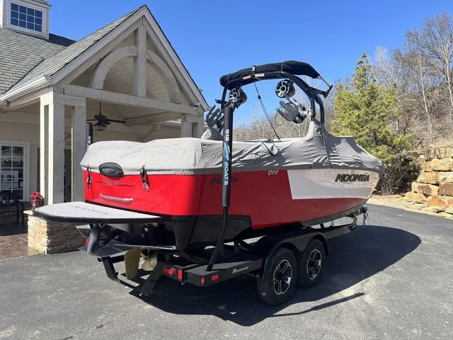 Slide: The Image of 2024 Moomba Mojo boat with cover on trailer, parked near a house. - 3