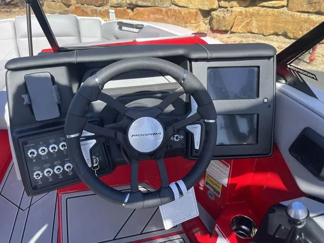 Slide: The Image of 2024 Moomba Mojo boat dashboard with steering wheel and digital displays. - 6