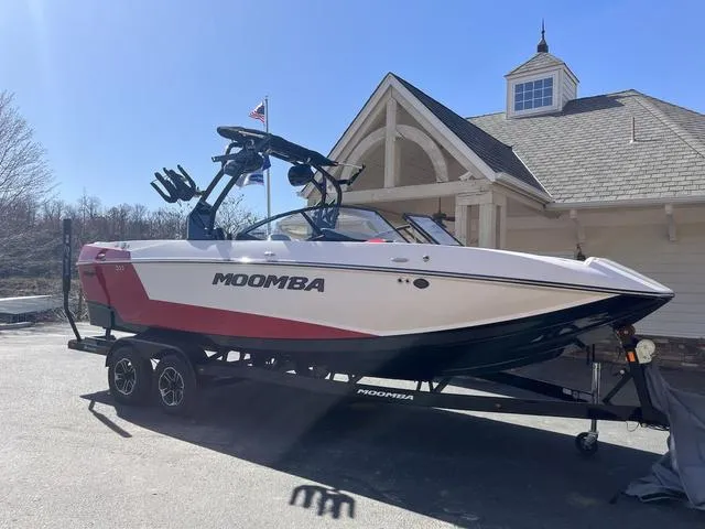 Slide: The Image of 2024 Moomba Mojo boat on trailer, parked near a building under clear blue sky. - 8
