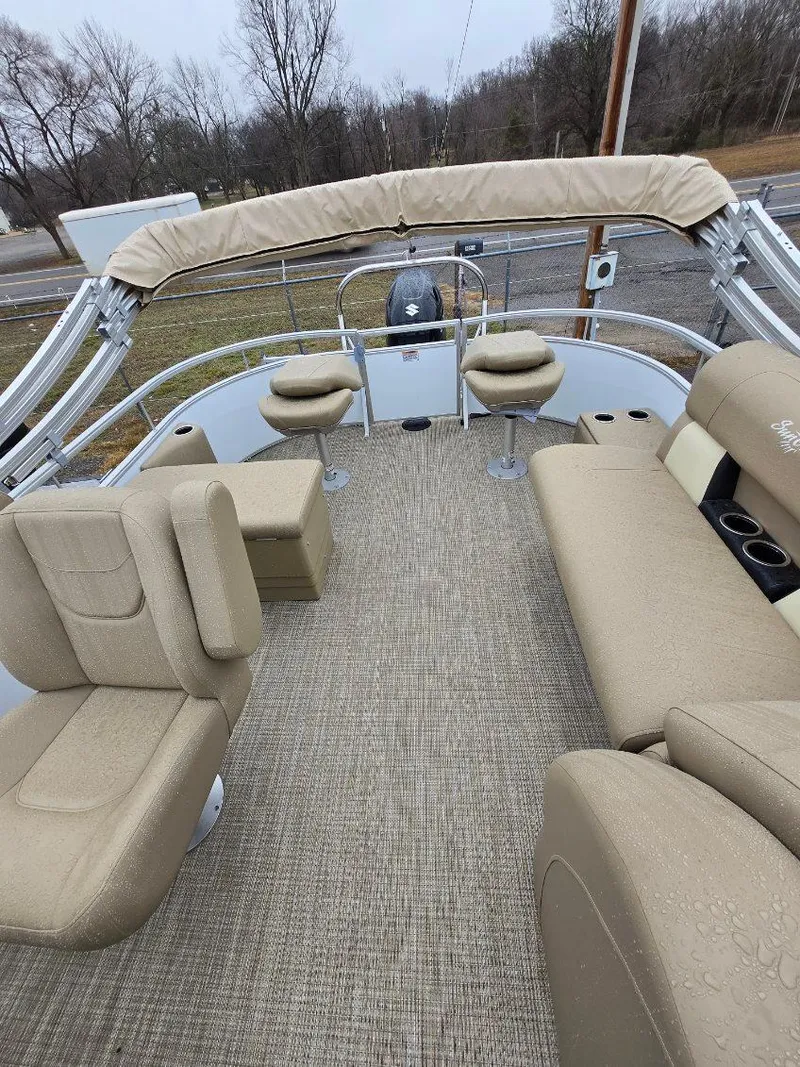 Slide: The Image of 2025 G3 SELECT 322SS pontoon boat with beige seating and canopy, parked outdoors. - 8