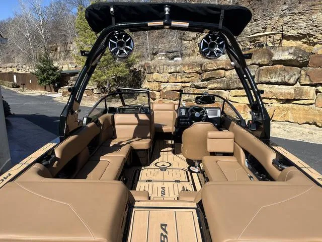 Slide: The Image of 2024 Moomba Mojo boat interior with tan seating and black tower speakers. - 10