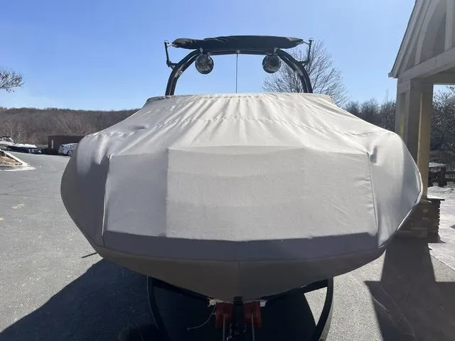 Slide: The Image of 2024 Moomba Mojo boat covered, parked outdoors on a sunny day. - 13