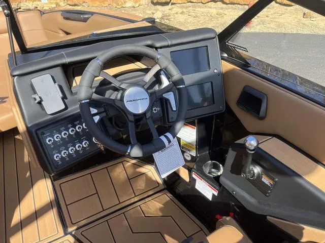 Slide: The Image of 2024 Moomba Mojo boat dashboard with steering wheel, touchscreen, and control panel. - 7