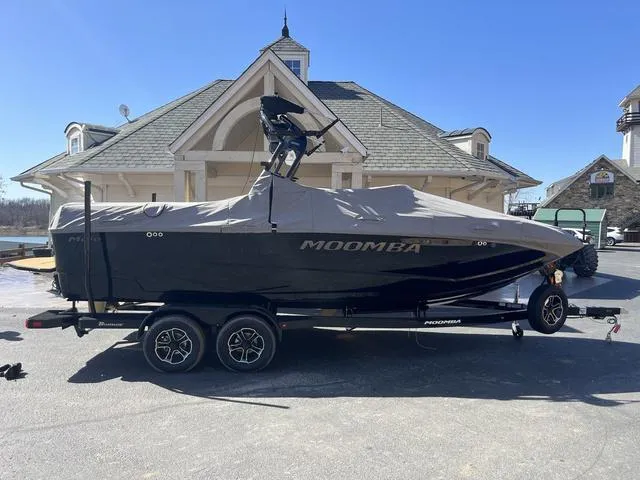 Slide: The Image of 2024 Moomba Mojo boat on trailer, covered, parked in front of a house. - 9