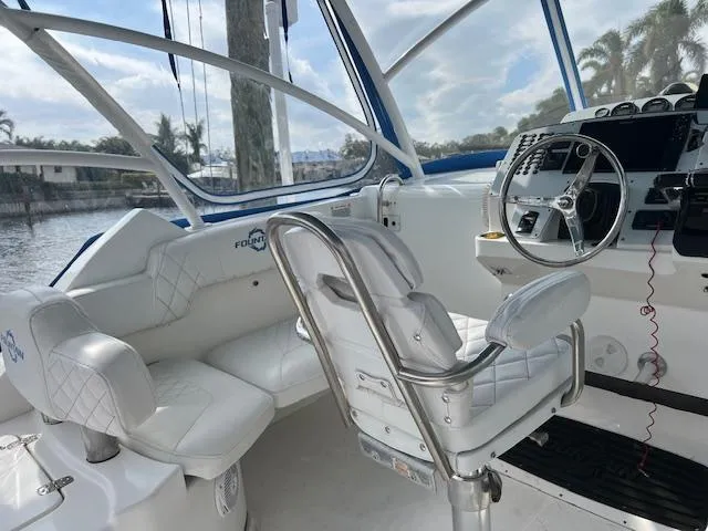 Slide: The Image of 2008 Fountain 33 SFC Sportfish Cruiser interior with white seating and steering console. - 11