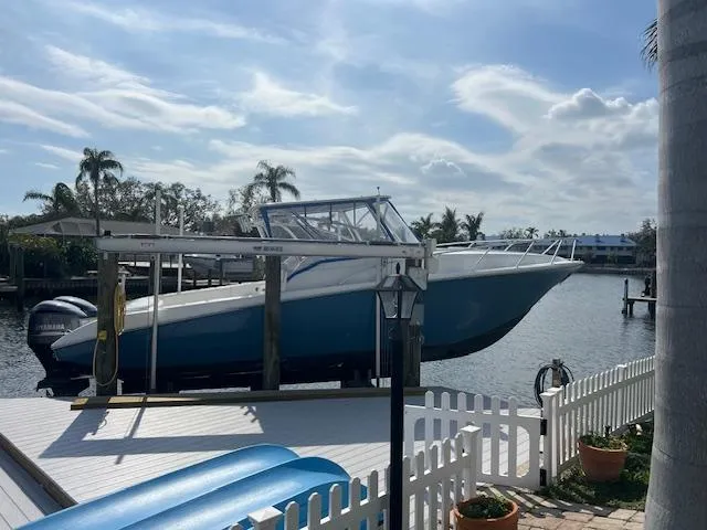 Slide: The Image of 2008 Fountain 33 SFC Sportfish Cruiser on lift by waterfront dock. - 6