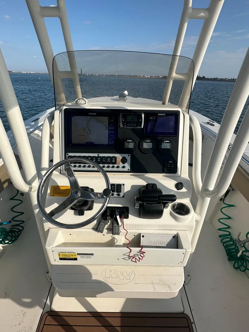 Slide: The Image of 2018 Key West 244 CC boat console with steering wheel and navigation equipment on open water. - 10