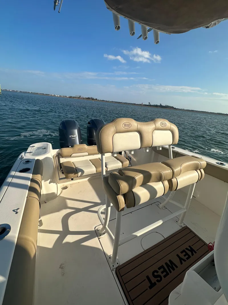 Slide: The Image of 2018 Key West 244 CC boat on water, featuring dual engines and beige seating. - 5