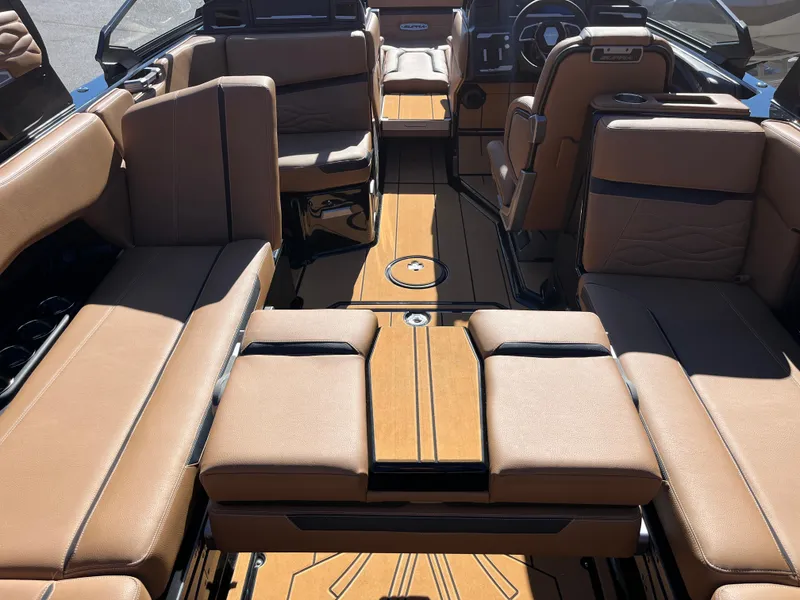 Slide: The Image of 2025 Supra SE boat interior with tan leather seating and wood-style flooring. - 36