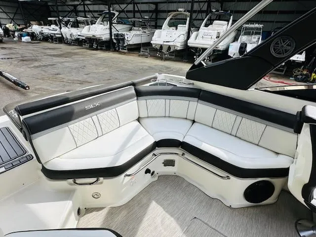 Slide: The Image of 2016 Sea Ray 250 SLX boat interior with luxurious seating in a marina setting. - 12