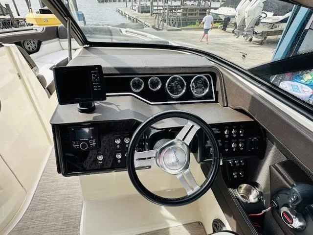 Slide: The Image of Interior dashboard of a 2016 Sea Ray 250 SLX boat, featuring steering wheel and gauges. - 18