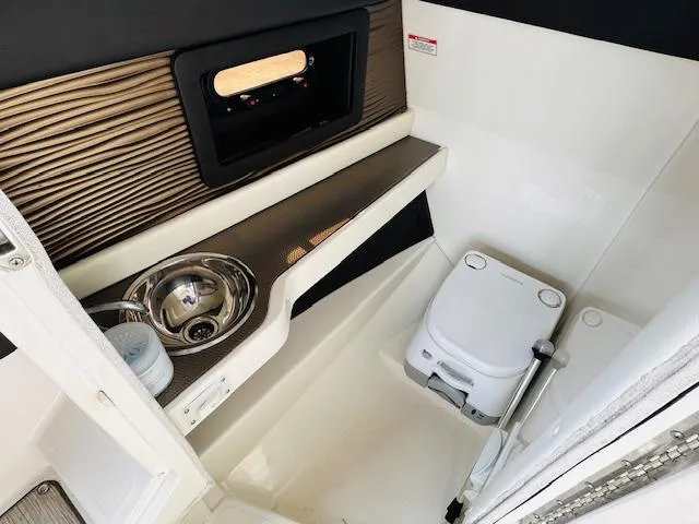 Slide: The Image of 2016 Sea Ray 250 SLX boat interior with sink and portable toilet. - 19