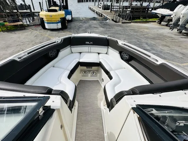 Slide: The Image of 2016 Sea Ray 250 SLX boat interior with white seating, dockside view. - 20