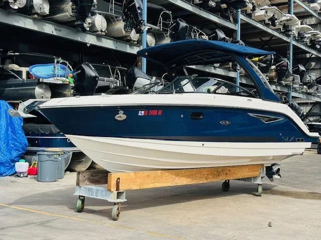 Slide: The Image of 2016 Sea Ray 250 SLX boat in storage, blue and white exterior, side view. - 3