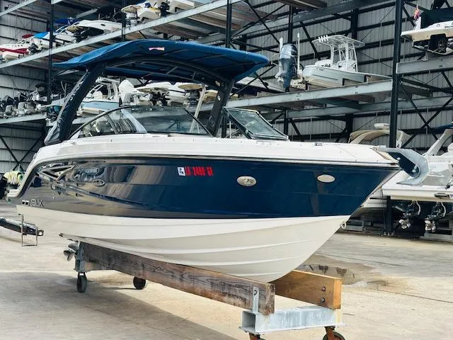 Slide: The Image of 2016 Sea Ray 250 SLX boat in storage, blue and white exterior, indoor marina setting. - 5